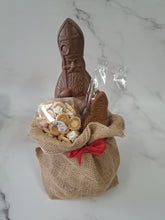 Load image into Gallery viewer, “Jute geschenkzak met rode strik, gevuld met een chocolade Sinterklaas, speculoos en nic-nackoekjes.”⠋
