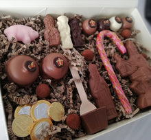 Load image into Gallery viewer, “Inhoud van de Sintpostbox large uitgestald op een lichte ondergrond, met Sint te paard, pralines, chocolademunten en chocostick.”
